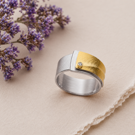 Overlappende zilveren met geelgouden ring en diamant